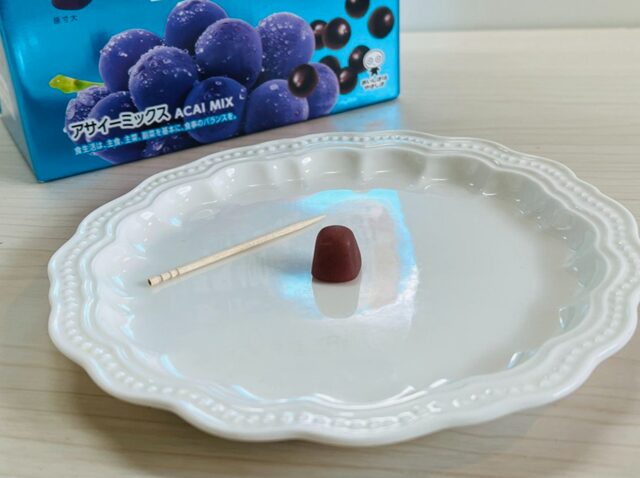 コストコのUHA味覚糖 グミサプリ 鉄&葉酸を皿にのせ、爪楊枝を添えてサイズ比較した写真。1粒の大きさや形状がわかる内容【商品番号90000】」