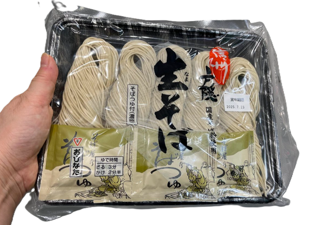 コストコのおびなた 戸隠そば そばつゆ付き 100g×5袋(つゆ22ml×5袋)。風味豊かな本格そばを手軽に楽しめるセット【商品番号562294】、商品を手に持っている様子」