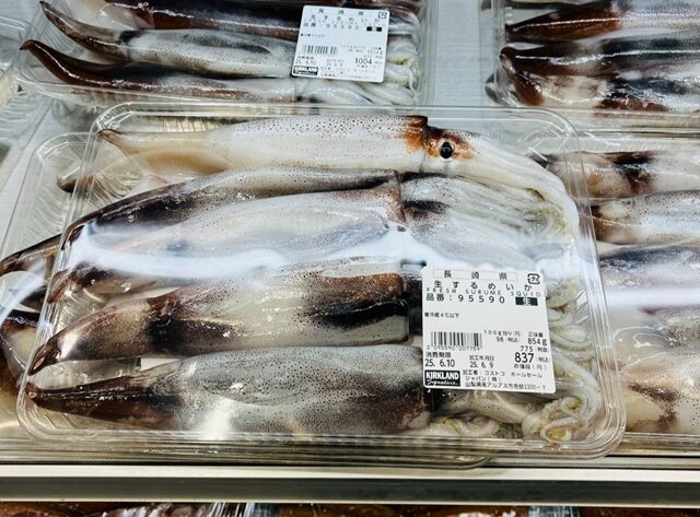 コストコ鮮魚コーナーで、生スルメイカのパックが半額価格で販売されている様子。鮮度の良いスルメイカが半額表示で並ぶ売り場