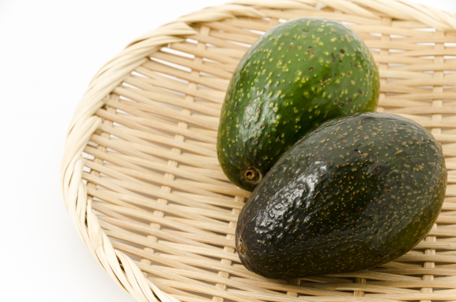 ざるの上に置かれたコストコのアボカド2個。追熟前の緑色と食べごろの茶色、熟度の違いがひと目でわかる比較【商品番号47019】」