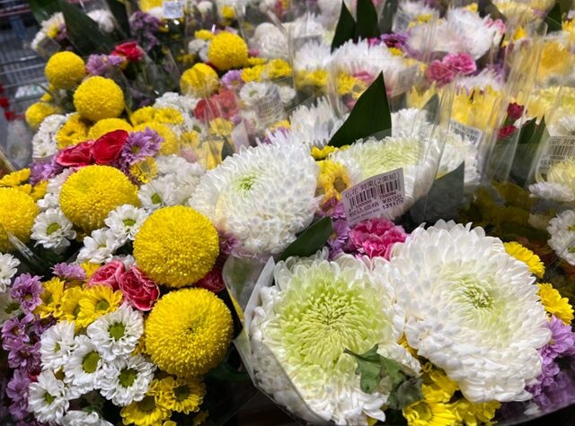 コストコの仏花売り場（5本×2束組）。白、ピンク、黄色の小菊やカーネーションを含む、2束セットの仏花。お供えや仏壇にぴったりな華やかなデザイ