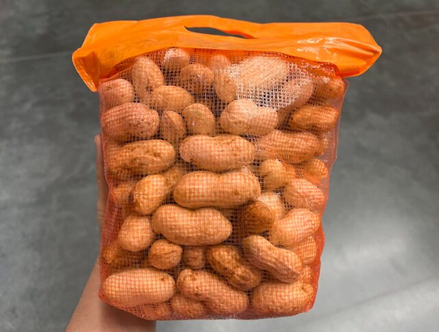 コストコ 生落花生 1kg（商品#55165）。袋の裏側のメッシュ部分から、大粒でぎっしり詰まった千葉県産落花生が見えるパッケージ。茹でておつまみに、炒っておやつに、そのままでも楽しめます