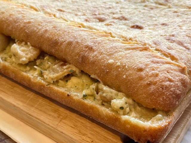 「コストコのガーリックチャパタ。ガーリックバターと大きめにカットされたにんにくがたっぷり挟まれた部分を写した写真