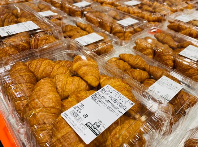 コストコ倉庫店のベーカリーコーナーに並ぶミニバタークロワッサン 20個入り ITEM#93326。バターの香り豊かな人気定番のクロワッサンが並ぶ売場