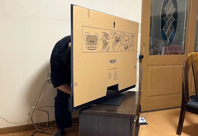 購入したコストテレビの裏側で配線をする筆者