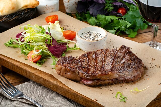 ステーキとグラスに注いだ赤ワイン